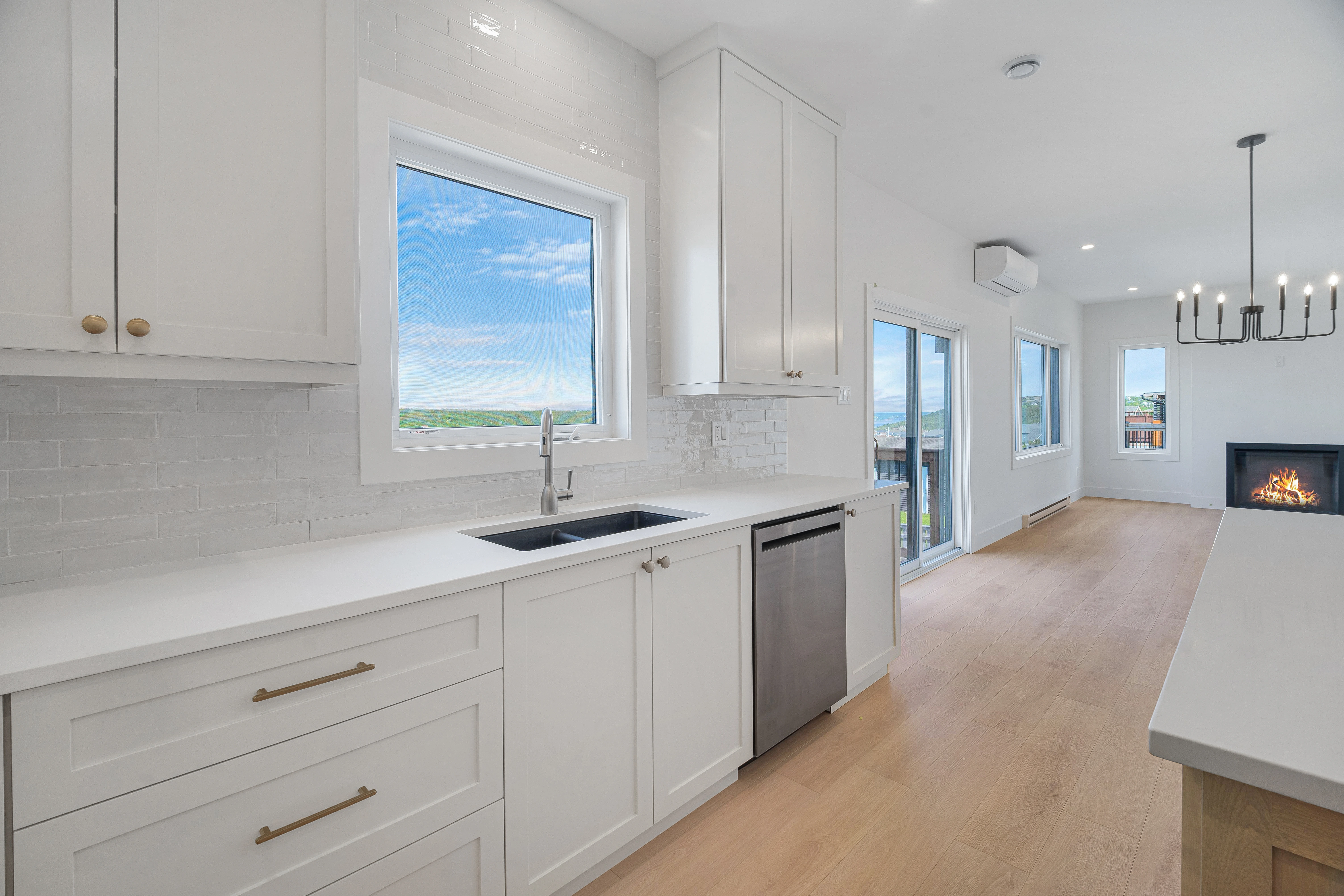 Saltwater House — Kitchen sink and worktop opening to the living area